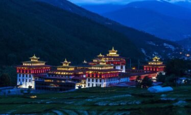 23 night view of the trashi chhu dzong in thimphu with rice fields