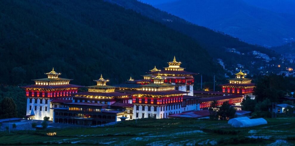 23 night view of the trashi chhu dzong in thimphu with rice fields