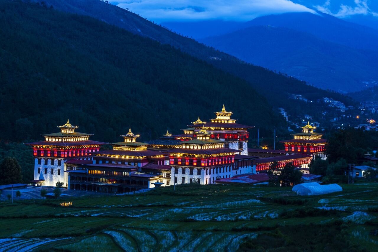 23 night view of the trashi chhu dzong in thimphu with rice fields
